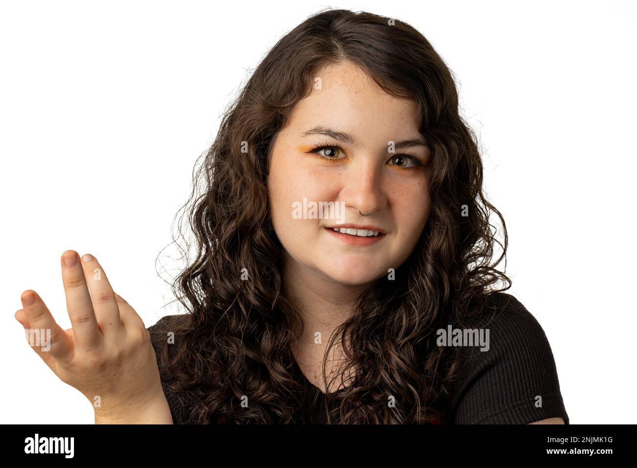 Süße junge Frau, die mit Gesten lächelt, auf weißem Hintergrund. Stockfoto