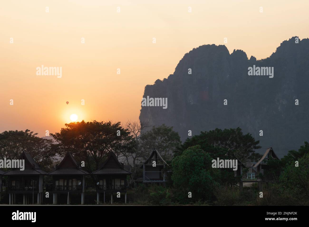 Vang Vieng, Sonnenuntergang in den Bergen mit Heißluftballonblick, Bungalow am Fluss, Vang Vieng, Laos Stockfoto