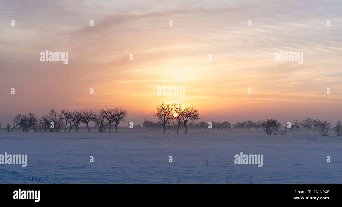 Wunderschöne Farben des Himmels bei der Sonne an einem verschneiten Tag im Winter Stockfoto