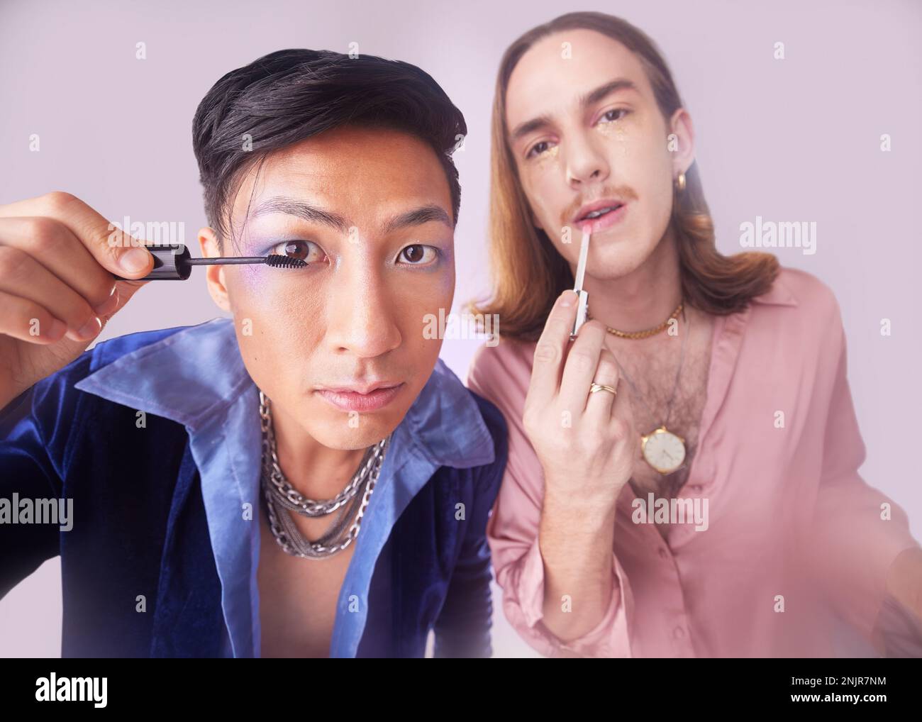 Make-up für Männer, Schwule und Mascara im Studio mit Genz-Freunden, Kosmetik und Kosmetik für Mode im Hintergrund. LGBTQ-Paar, kosmetisch oder Porträt für Stockfoto