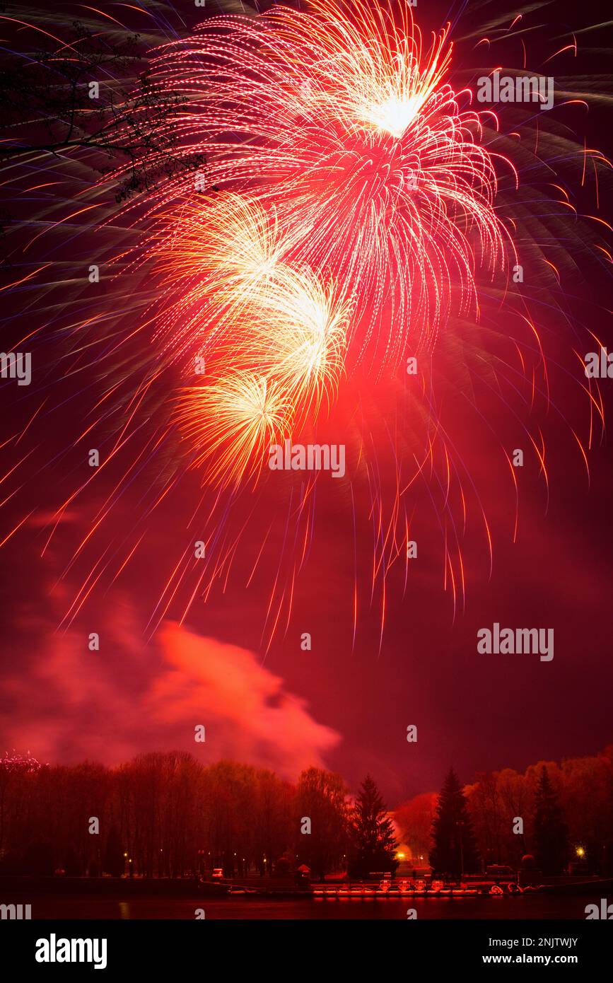 Helle mehrfarbige Feuerwerkslichter am schwarzen Nachthimmel während der Feiertage Stockfoto