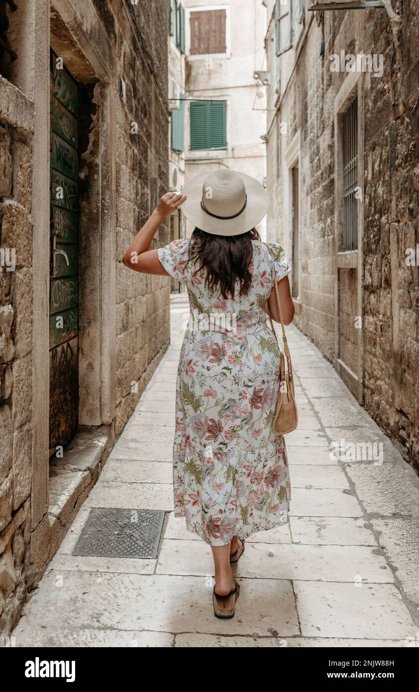 Rückansicht einer Frau in Blumenkleid, die in einer alten Gasse in Split, Kroatien, steht Stockfoto