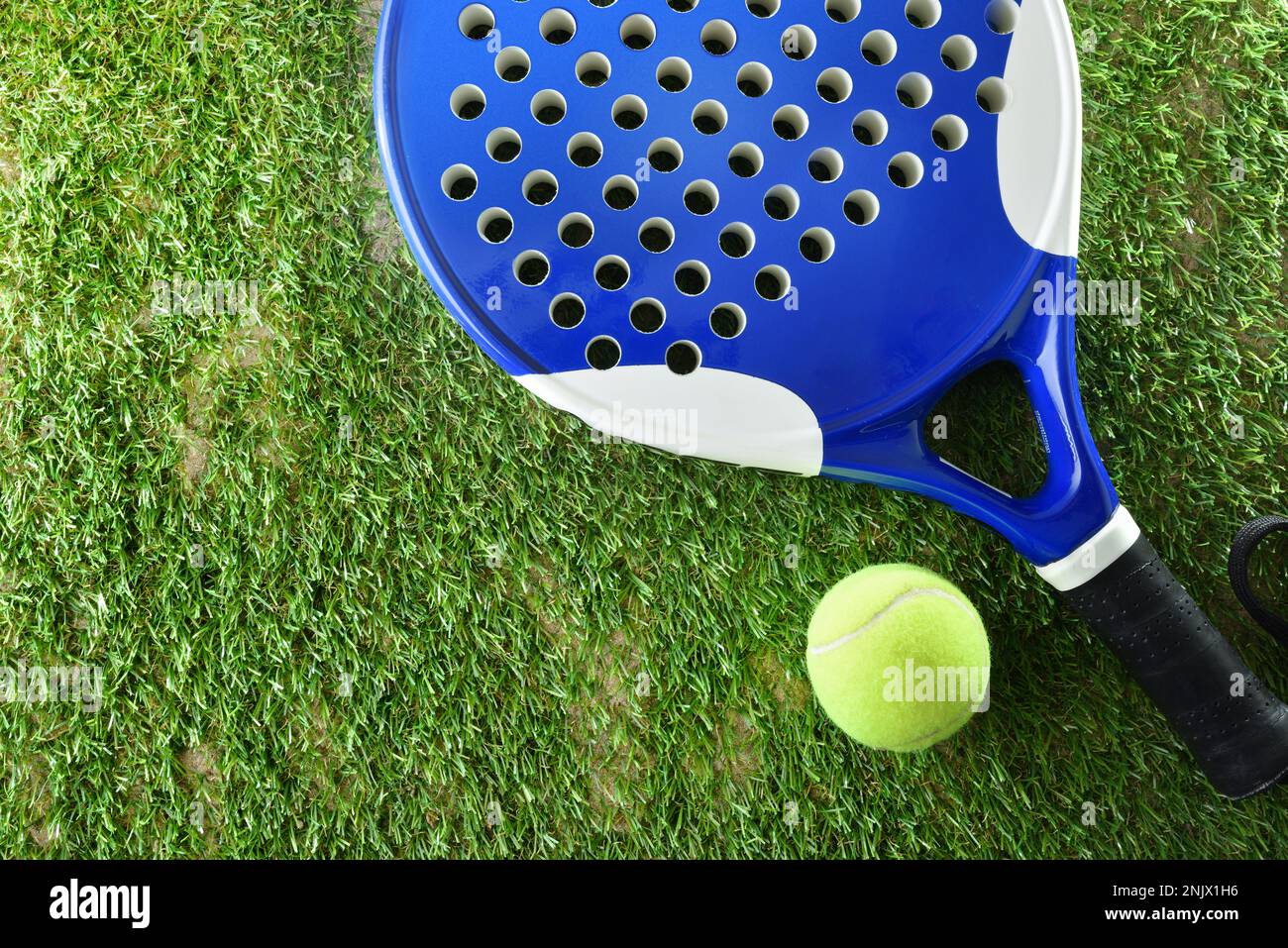 Hintergrund von Padel-Schläger und Ball auf Kunstrasenboden auf dem Freiluftplatz. Draufsicht. Stockfoto