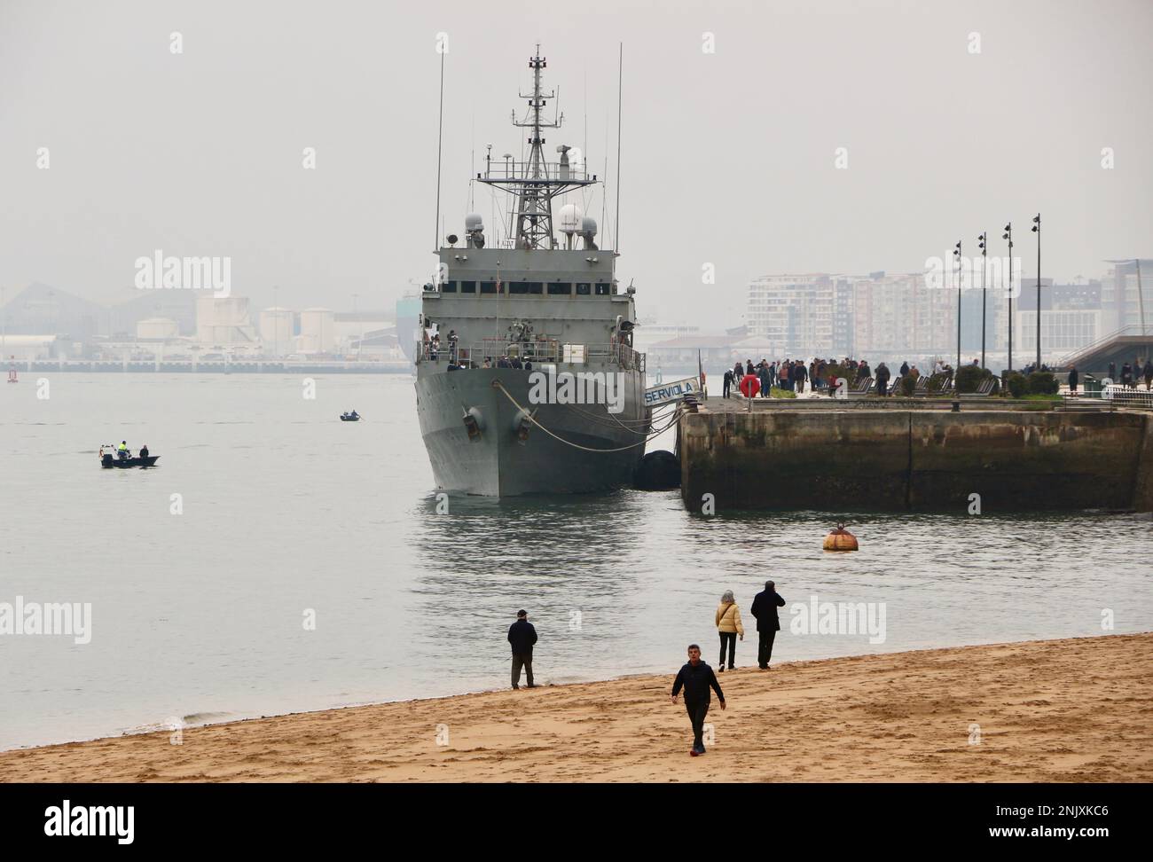 Menschen am Strand mit dem spanischen Patrouillenboot Serviola P-71, das für die Öffentlichkeit geöffnet ist, liegen im Hafengebiet von Gamazo der Santander Bay Cantabria Spanien Stockfoto