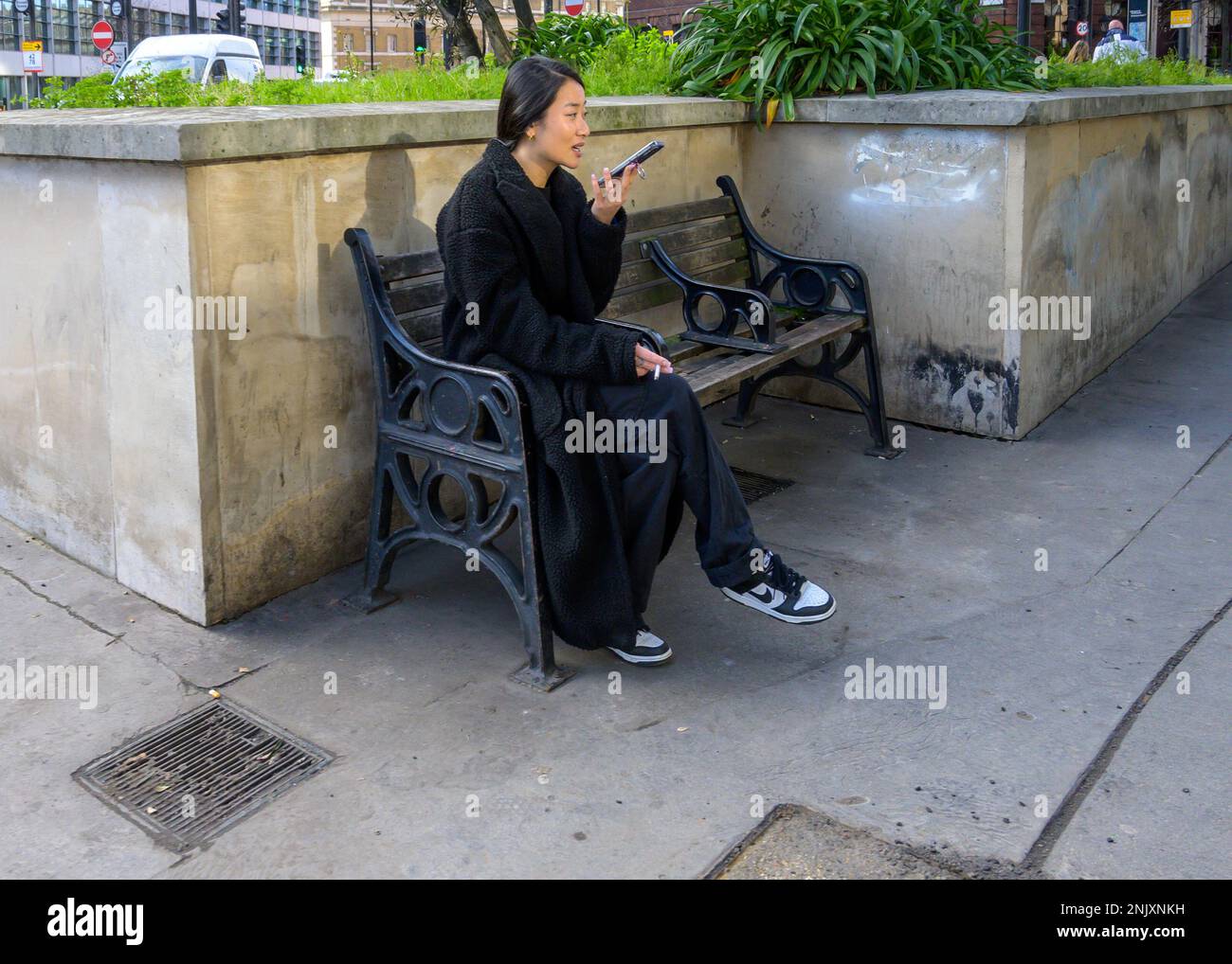 London, England, Großbritannien. Junge Japanerin auf ihrem Handy Stockfoto