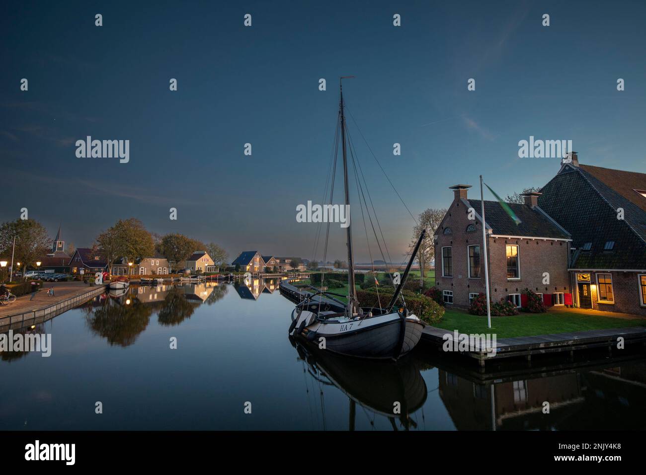 Gaastmeer auf dem Wijdesloot Kanal mit Flachboot nach Sonnenuntergang, Niederlande, Frisia Stockfoto