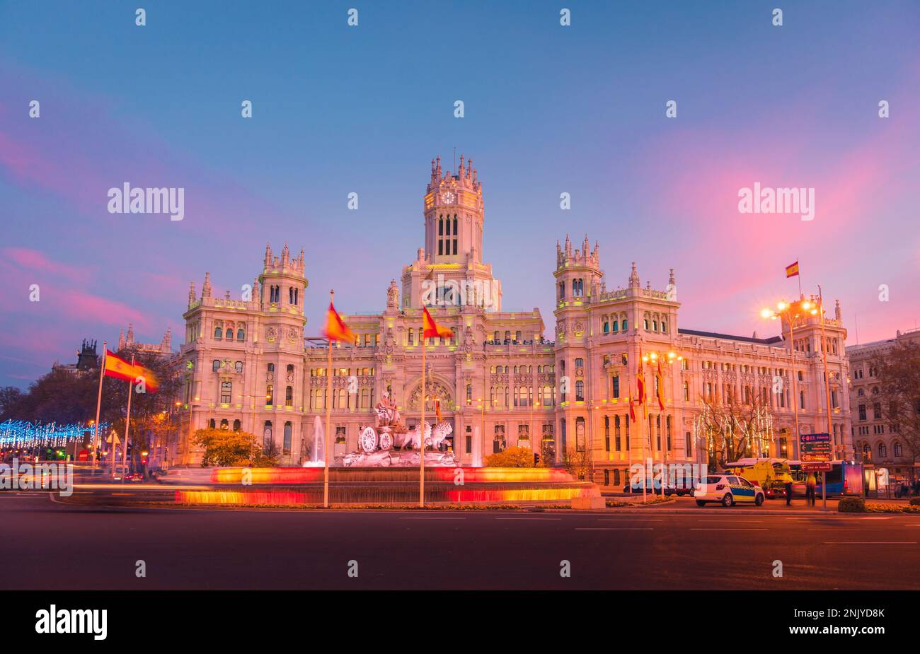 Beleuchteter historischer Palast mit leuchtenden Lichtern am Plaza de Cibeles in Madrid am Abend Stockfoto