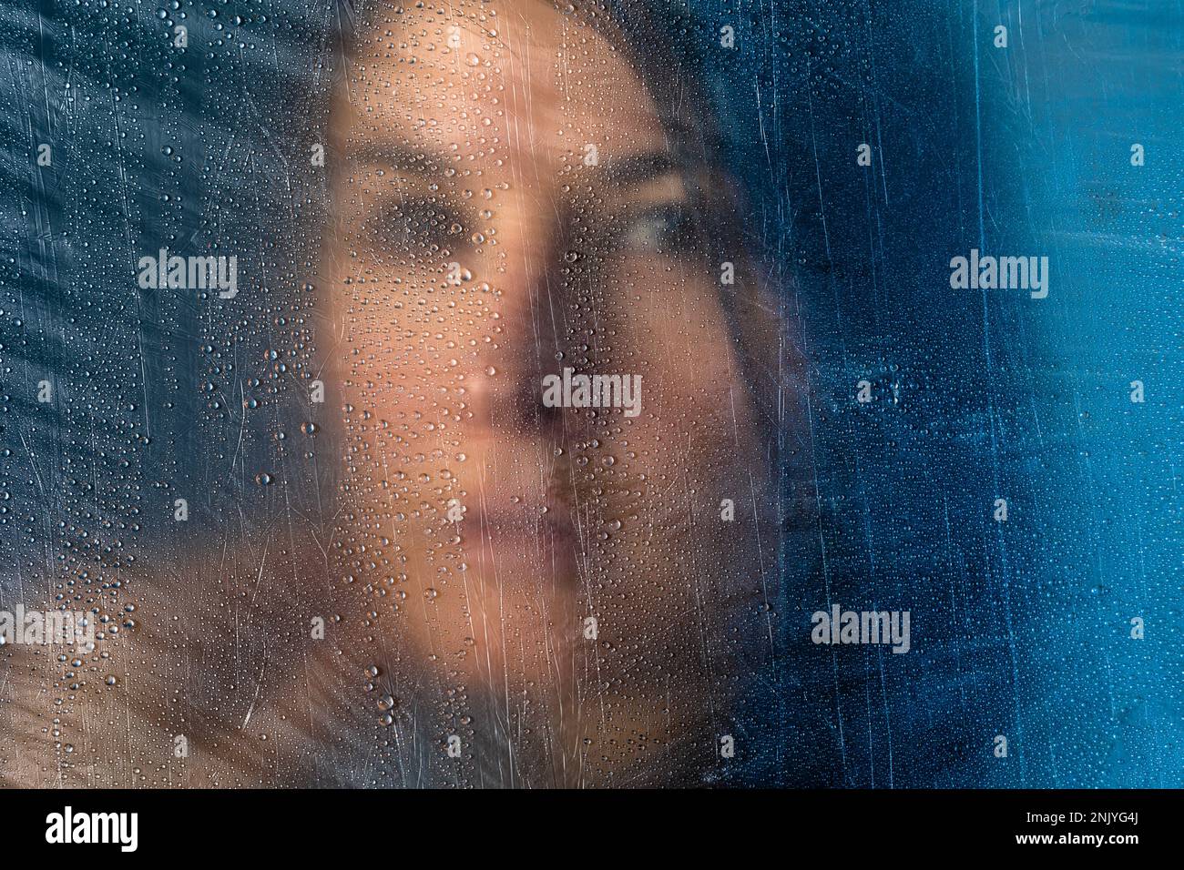 Frauenporträt hinter dem transparenten Zellophan-Konzept des Kunststoffverbrauchs und der globalen Verschmutzung Stockfoto