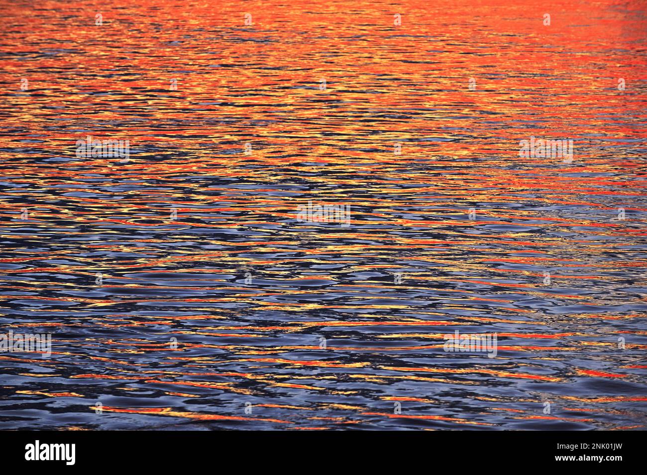 Nahaufnahme farbenfrohe abstrakte Sonnenaufgangsreflexion auf der Donau in Galati, Rumänien Stockfoto
