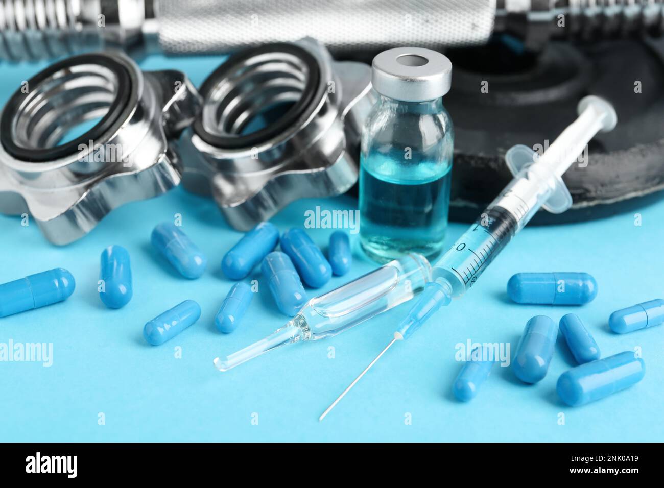 Verschiedene Drogen und Sportgeräte auf hellblauem Hintergrund. Dopingkontrolle Stockfoto