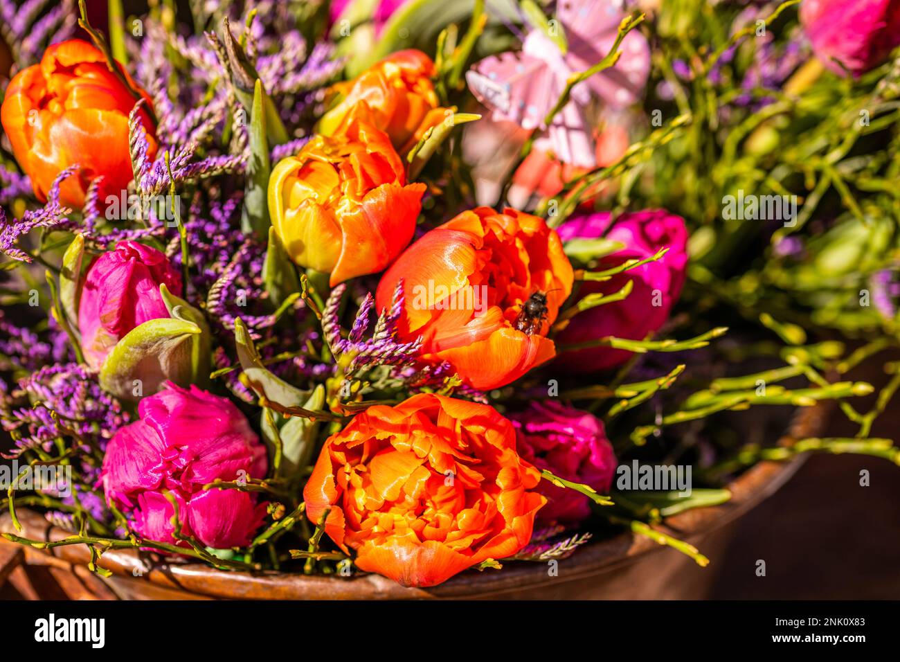 Verschiedene Blumen und Setzlinge in der Nähe des Eingangs zum Blumenladen, Frühling, osterkonzept Stockfoto