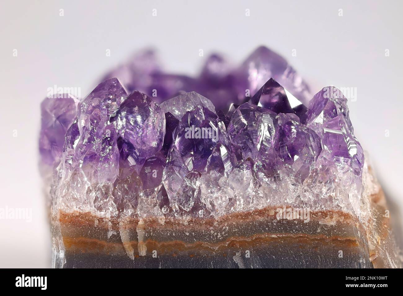 Amethyst ist eine fliederfarbene Quarzsorte. Hier sind Kristalle, die von einem geschliffenen Geode freigelegt wurden. Stockfoto