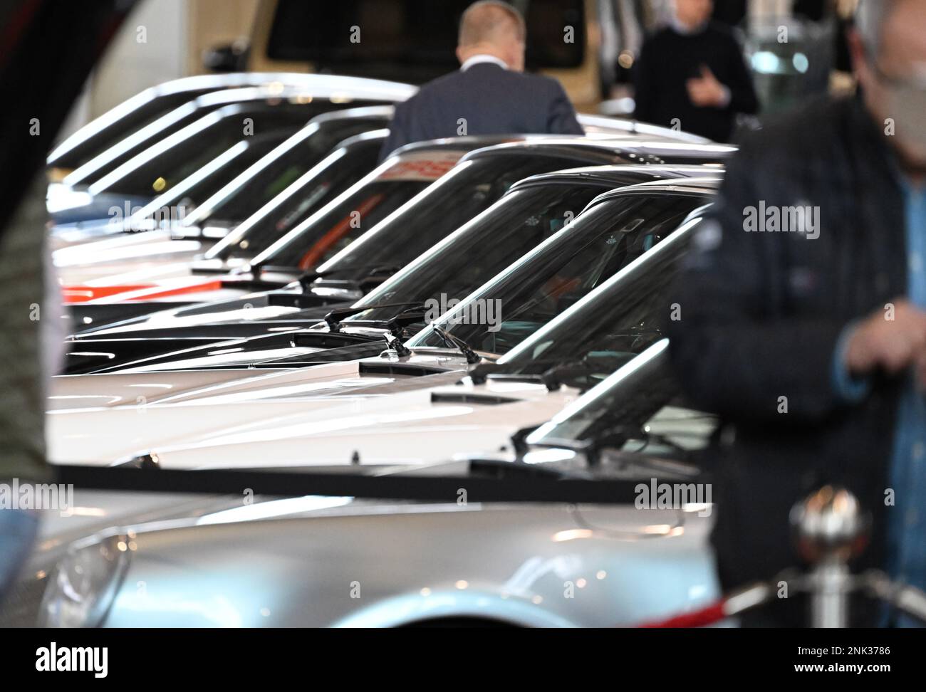 Stuttgart, Deutschland. 23. Februar 2023. Beucher auf der Messe Retro Classics werfen Sie einen Blick auf alte Porsche-Fahrzeuge in den Hallen der Messe Stuttgart. Auf der Retro Classics Messe, die den Veranstaltern zufolge die weltweit größte Fachmesse für Fahrkultur ist, werden hauptsächlich historische Autos und Zweiräder gezeigt. Kredit: Bernd Weißbrod/dpa/Alamy Live News Stockfoto