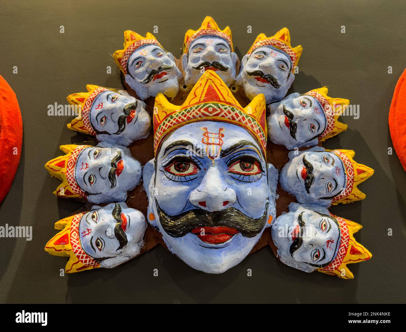Handgemachter farbenfroher Tribal-Look der Gesichtsmaske Ravan Souvenir hängt auf einfarbigem schwarzen Hintergrund. Selektiver Fokus auf Objekt. Stockfoto