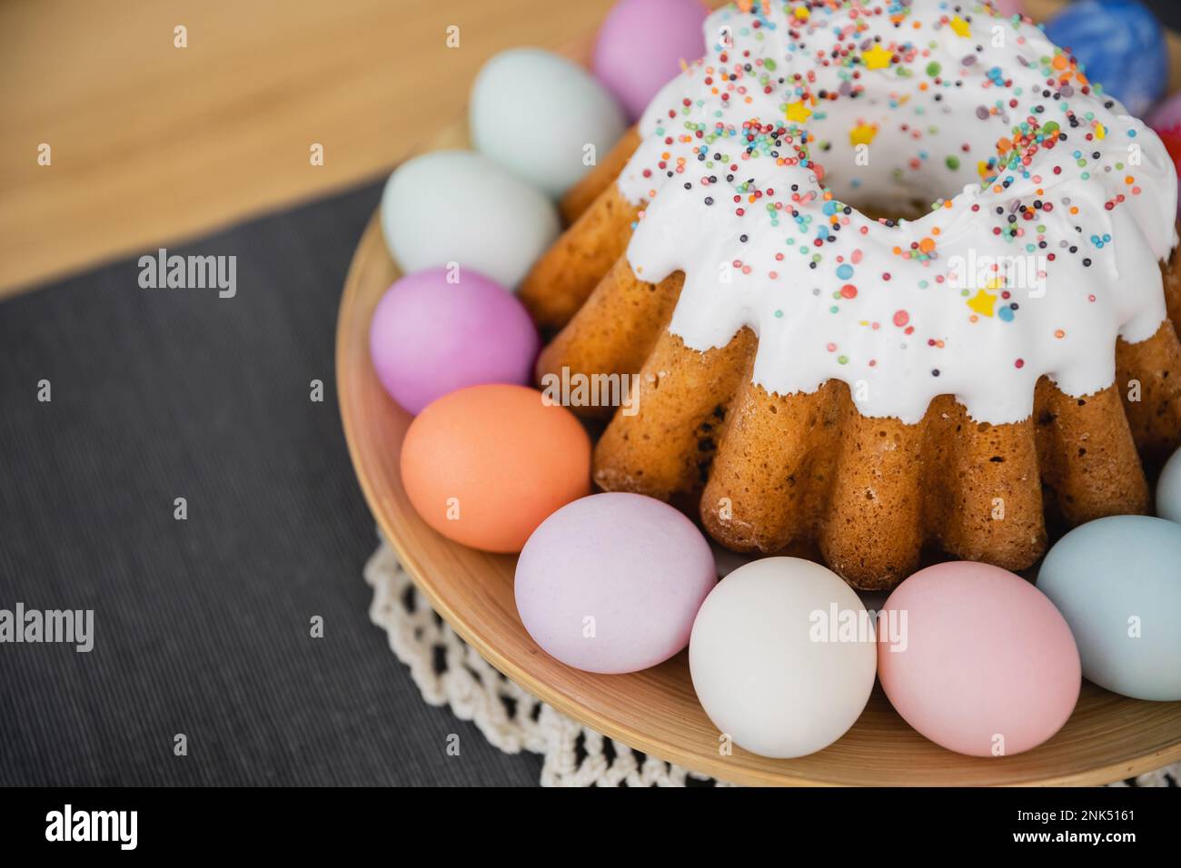 Blick aus einem hohen Winkel auf süßen Osterkuchen und gemalte pastellfarbene Eier auf dem Tisch zu Hause Stockfoto