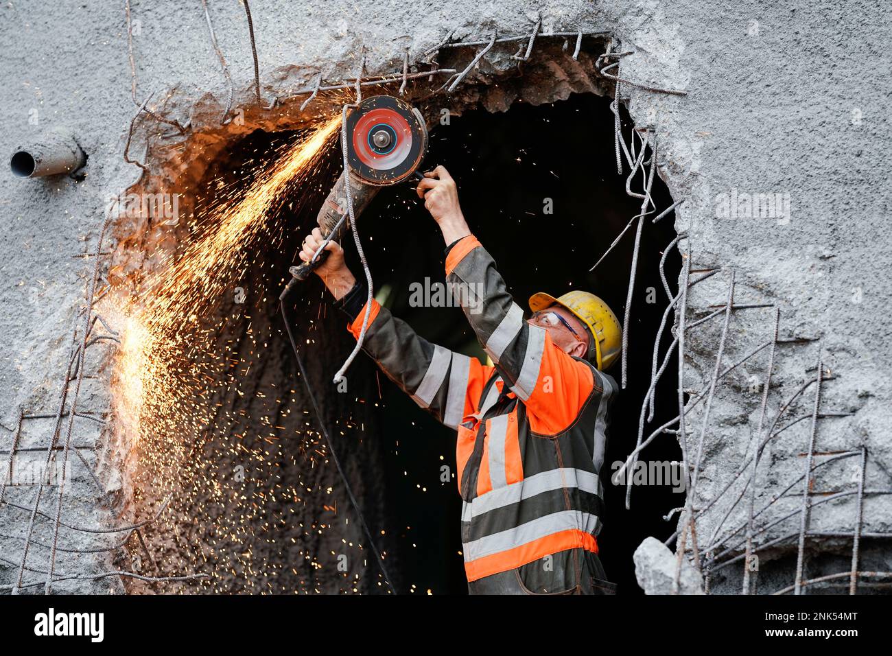 23. Februar 2023, Rheinland-Pfalz, Imsweiler: Ein Bauarbeiter verwendet während des Tunneldurchbruchs im Mühlberg-Tunnel einen Winkelschleifer. Der Mühlberg-Tunnel ist Teil der Umgehungsstraße der Bundesautobahn 48, um die Gemeinde Imsweiler vom Verkehr zu befreien. Foto: Uwe Anspach/dpa Stockfoto