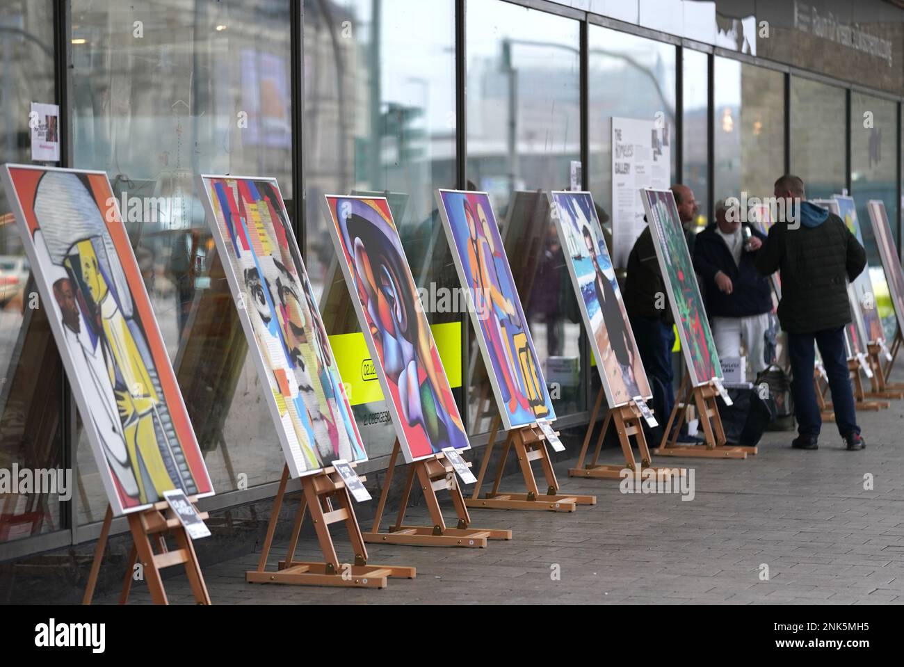 23. Februar 2023, Hamburg: Groformatige Gemlde, gemalt mit Hilfe knstlicher  Intelligenz (AI), stehen auf Staffeleien in der Pop-up-Ausstellung  "Obdachlose Galerie" vor dem Jupiter, dem ehemaligen Karstadt Sport  Gebude, im Stadtzentrum. Mit Hilfe