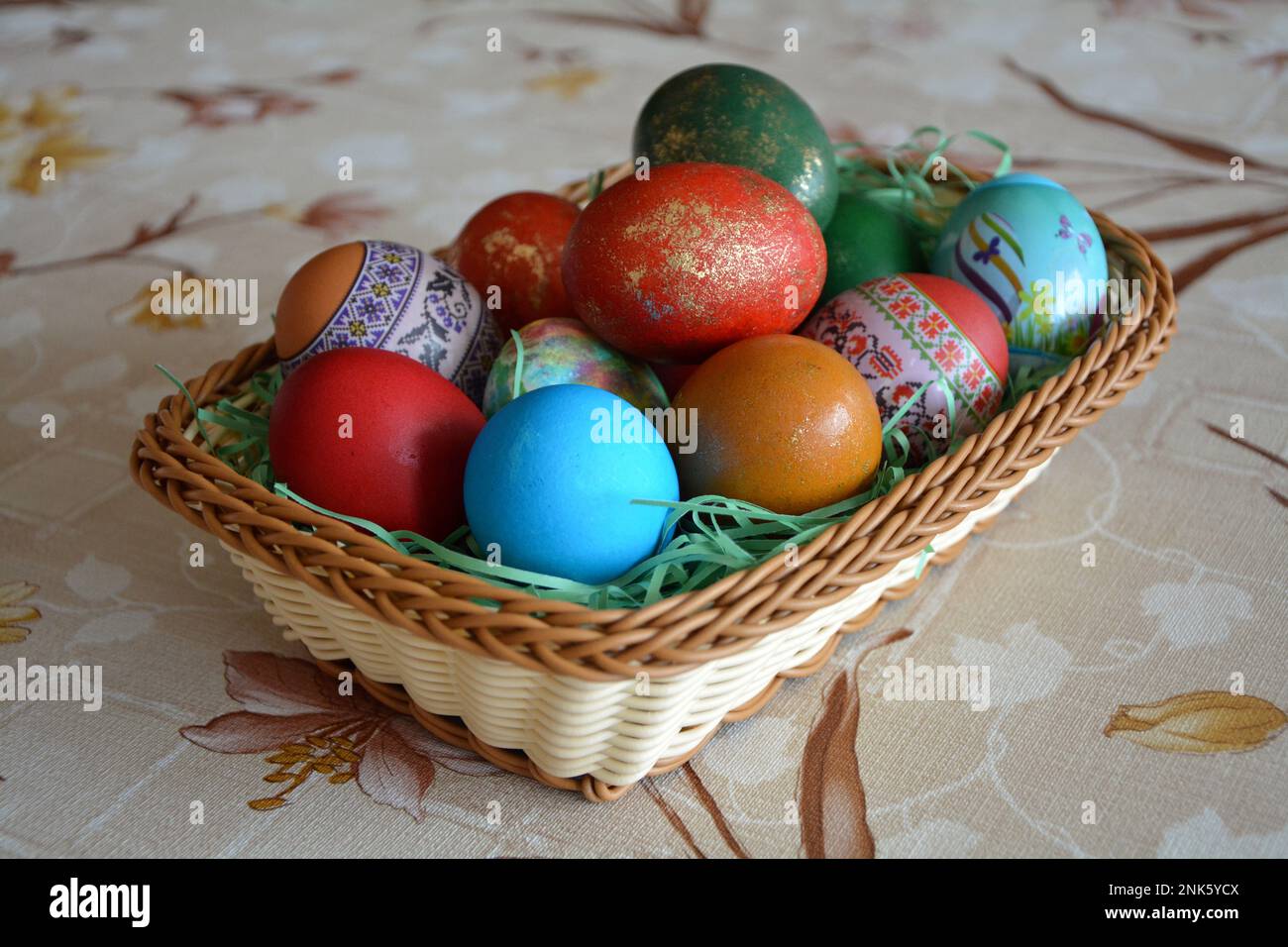 Nahaufnahme eines Webkorbs mit bunten gefärbten Eiern für die traditionelle Osterfeier in Bulgarien im april. Horizontales Bild mit selektivem FO Stockfoto