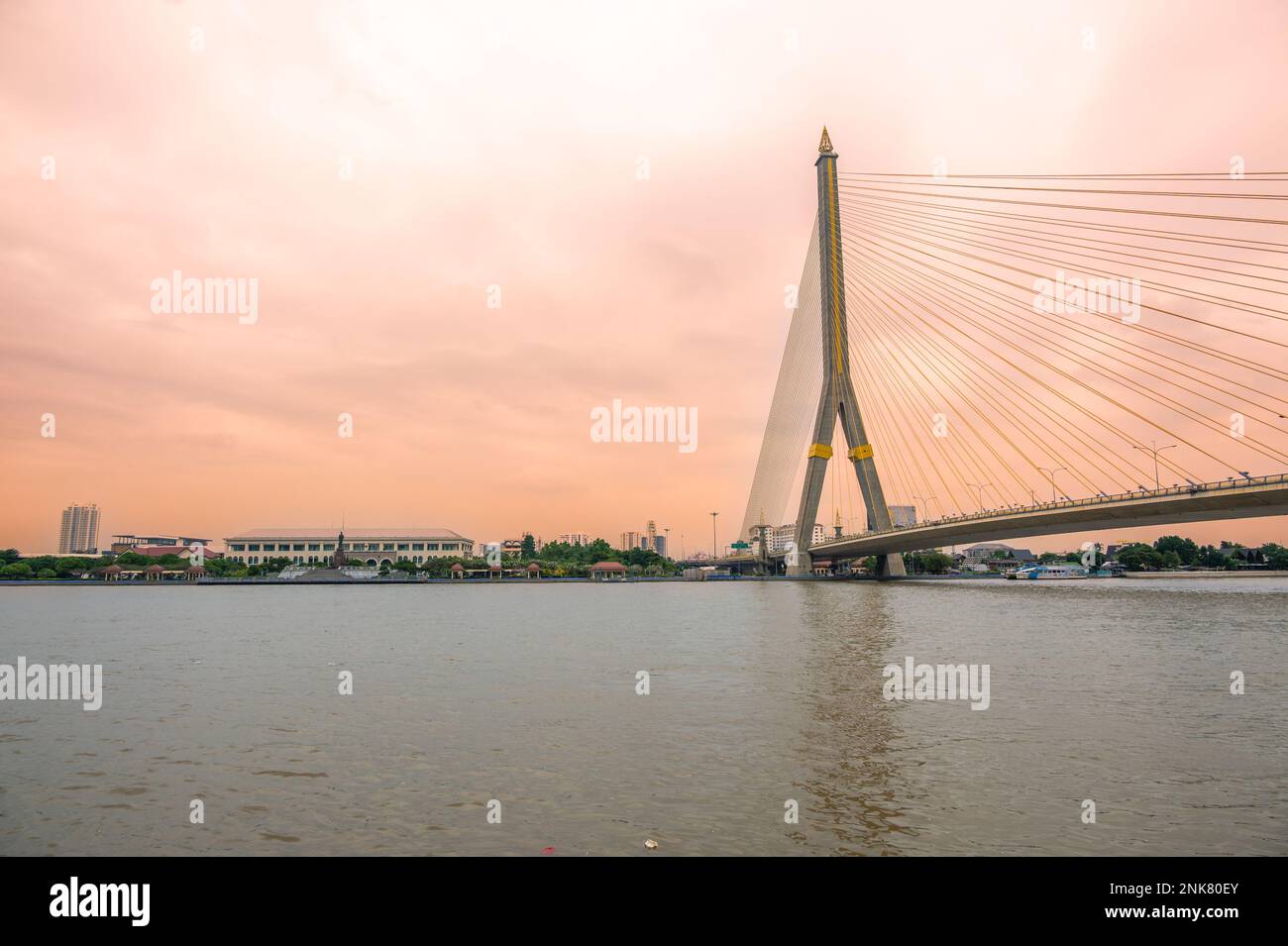 Blick auf die Brücke von Bangkok über den Fluss während des Sonnenuntergangs. Stockfoto