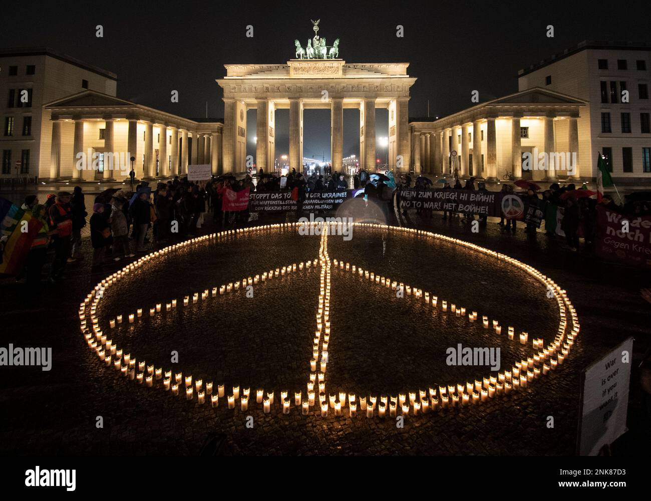 Berlin, Deutschland. 23. Februar 2023. Anlässlich des Jahrestages des russischen Angriffskrieges gegen die Ukraine stellten Aktivisten ein übergroßes Friedenszeichen aus Kerzen vor das Brandenburger Tor. Kredit: Paul Zinken/dpa/Alamy Live News Stockfoto