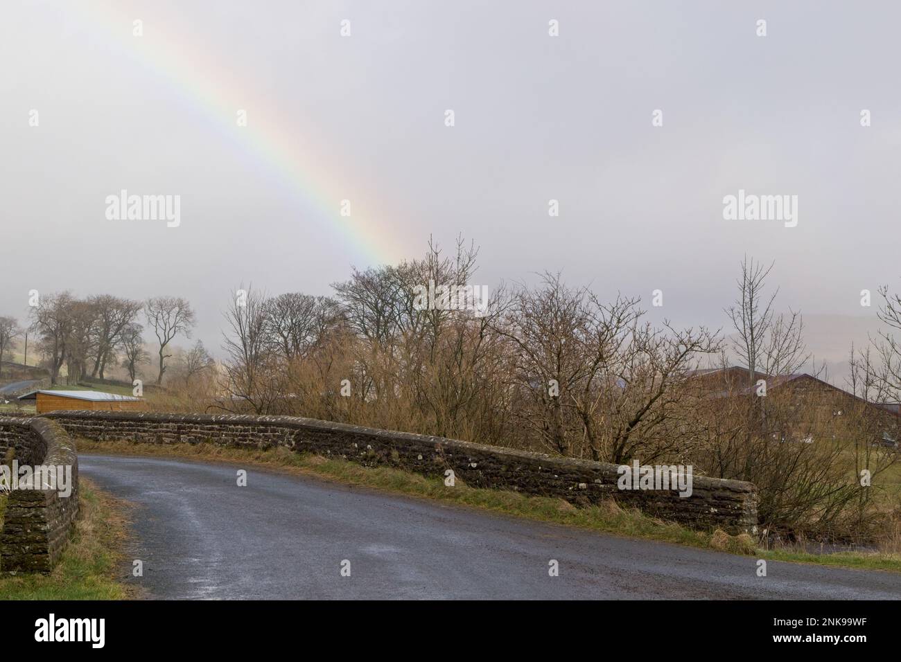 Ein schwacher Regenbogen vor einem grauen Himmel im ländlichen Yorkshire, England. Stockfoto