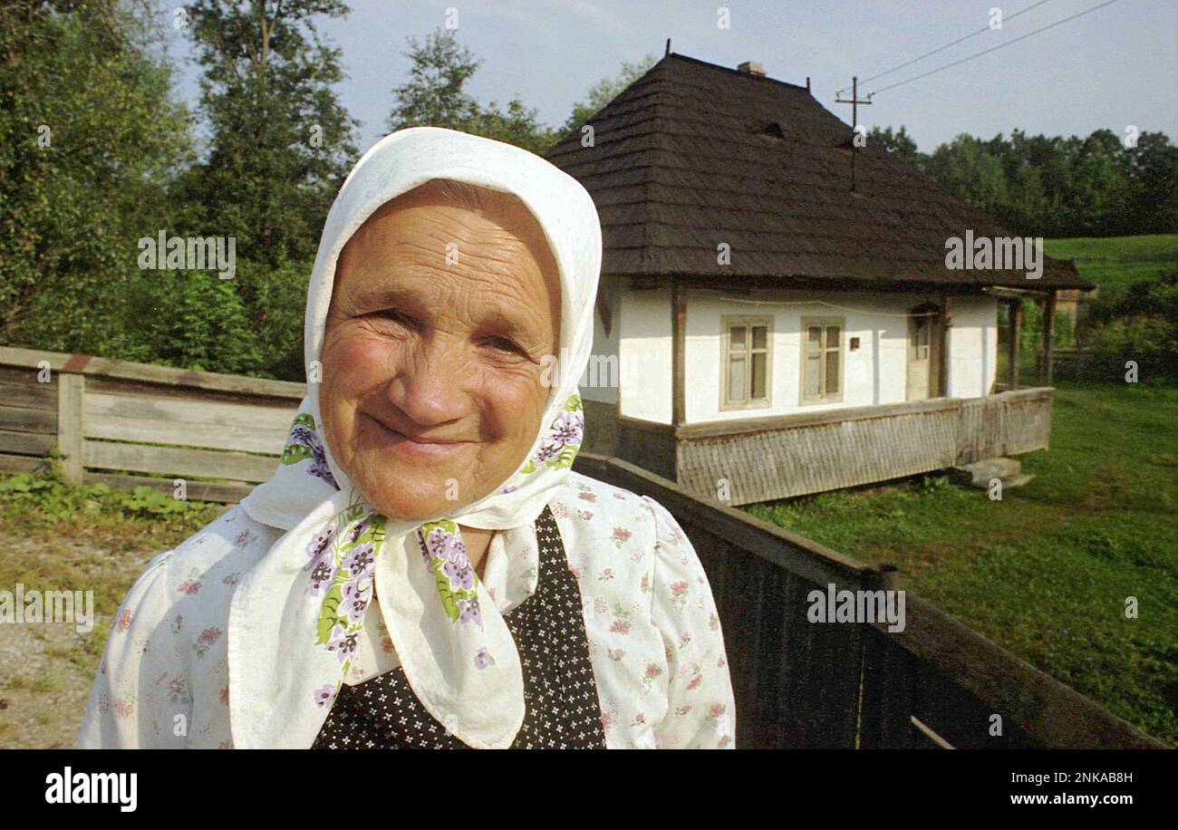 Solonetu Nou, Suceava County, Rumänien, 2001. Porträt einer älteren Frau vor ihrem traditionellen Holzhaus. Stockfoto