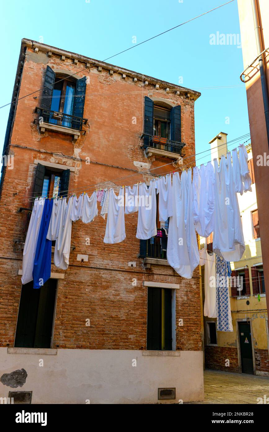 Typische Stadtecke mit antiken bunten Gebäuden trocknen Kleidung an einem Kleidungsstück im Freien an sonnigen Sommertagen. Venedig, Italien. Stockfoto