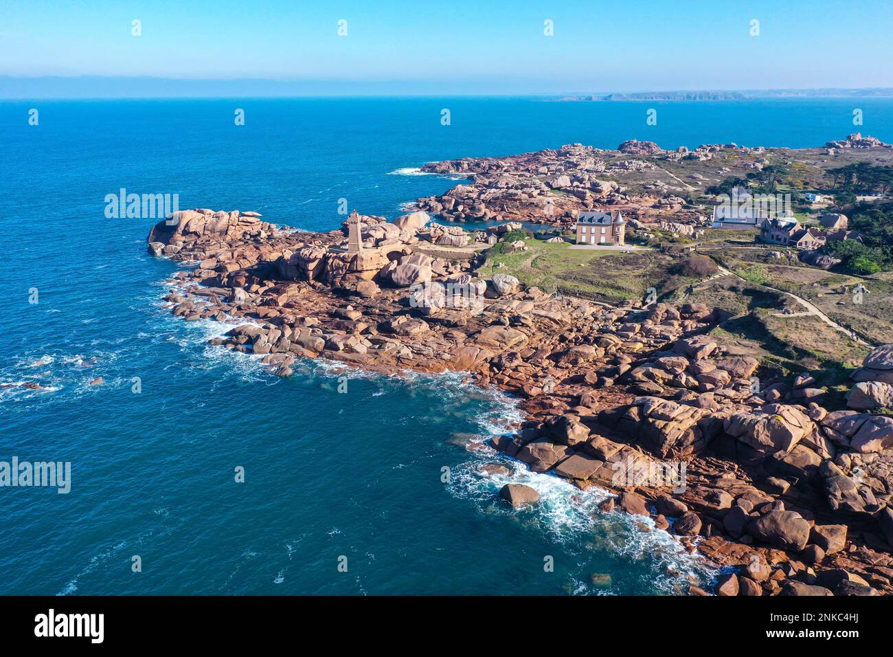 Blick auf die felsige Küste von Ploumanach, Perros-Guirec mit Leuchtturm Phare de Mean Ruz, Cote de Granit Rose, Departement Cotes-dArmor, Region Bretagne Stockfoto