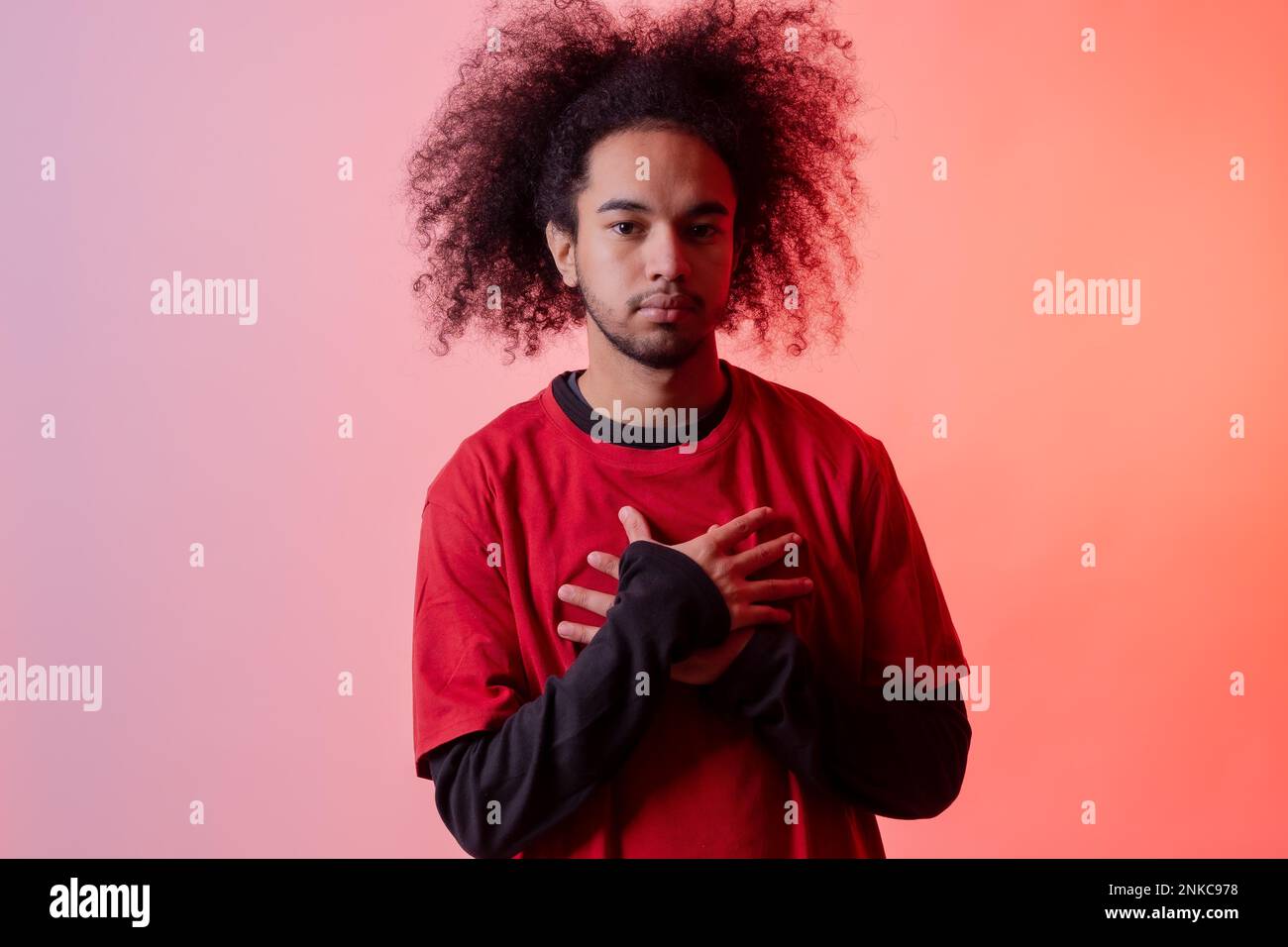 Porträt mit roter LED. Junger Mann mit Afrohaar auf weißem Hintergrund Stockfoto