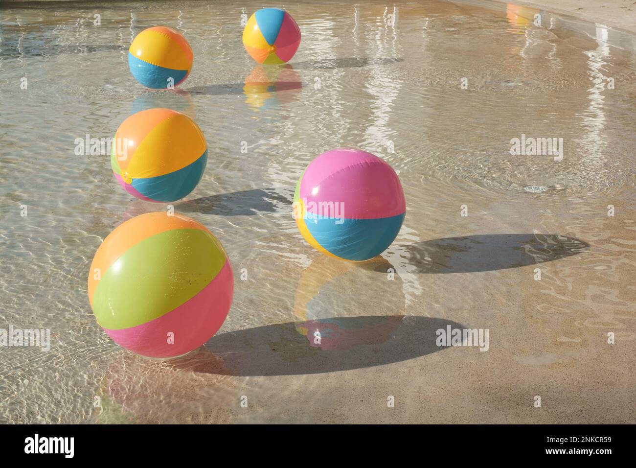 Strandbälle schweben an einem Sommertag im Wasser eines Resortpools. Stockfoto
