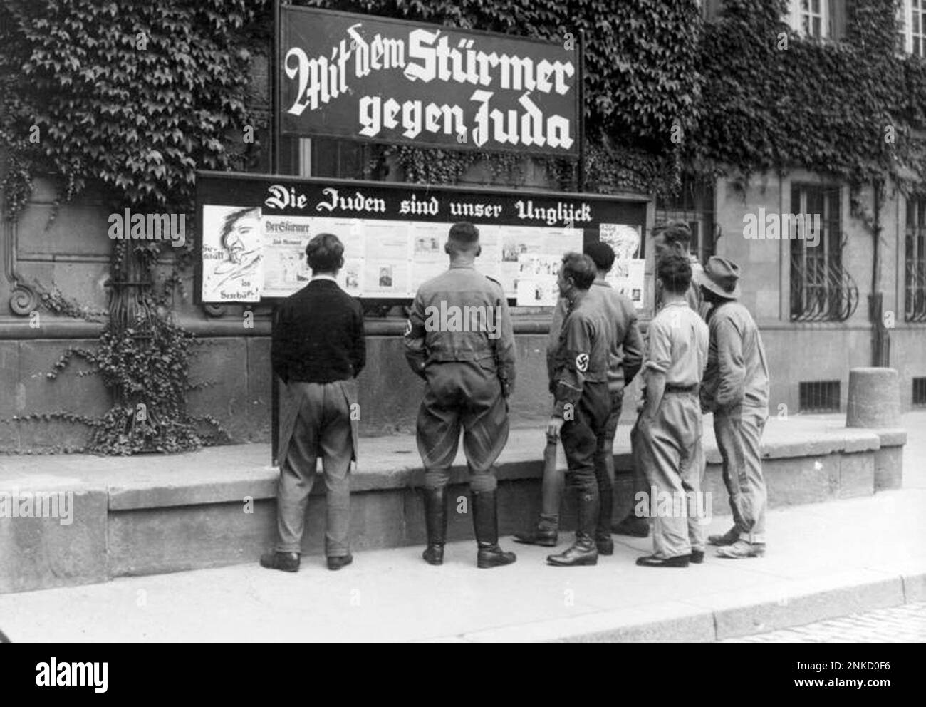 Öffentliche Lektüre von Julius Streichers antisemitischer Zeitung der Stürmer, Worms, 1935. Julius Streicher war ein gewalttätiger antisemitischer Nazi (und im Allgemeinen ein gewalttätiger Mann) und seine tollwütige und hysterische Zeitung die Stürmer hat viel dazu beigetragen, die Flammen des antijüdischen Gefühls im Vorfeld des Krieges zu schüren. Photo Bundesarchiv, Bild 133-075 / Unbekannt / CC-BY-SA 3,0, CC BY-SA 3,0 de, https://commons.wikimedia.org/w/index.php?curid=5338071 Stockfoto