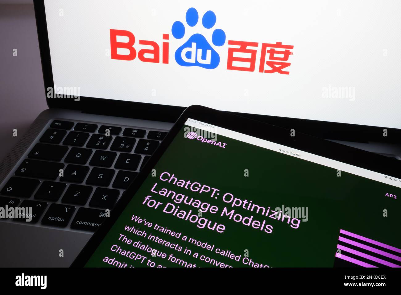 ChatGPT-Chat bot-Anmeldebildschirm auf Tablet und verwischtes Baidu-Firmenlogo auf dem Notebook im Hintergrund. Konzept für den Wettbewerb. Stafford, Vereinigtes Königreich Stockfoto