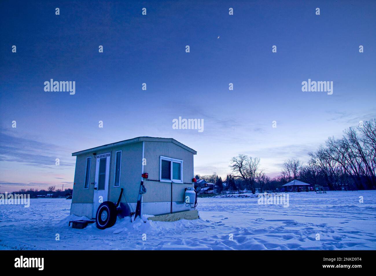 Mitten im Winter befindet sich an einem See in Minnesota eine Hütte für Eisangler im Eis und Schnee. Stockfoto