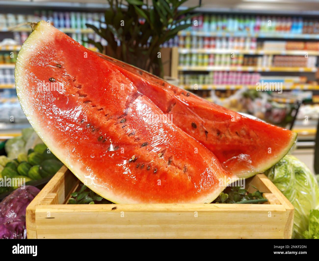 Wassermelone in Stücken geviertelt, zum Verkauf verpackt in Folie Stockfoto