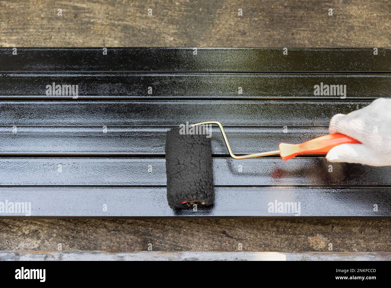 Arbeiter lackieren Stahlpfosten auf der Baustelle. Stockfoto