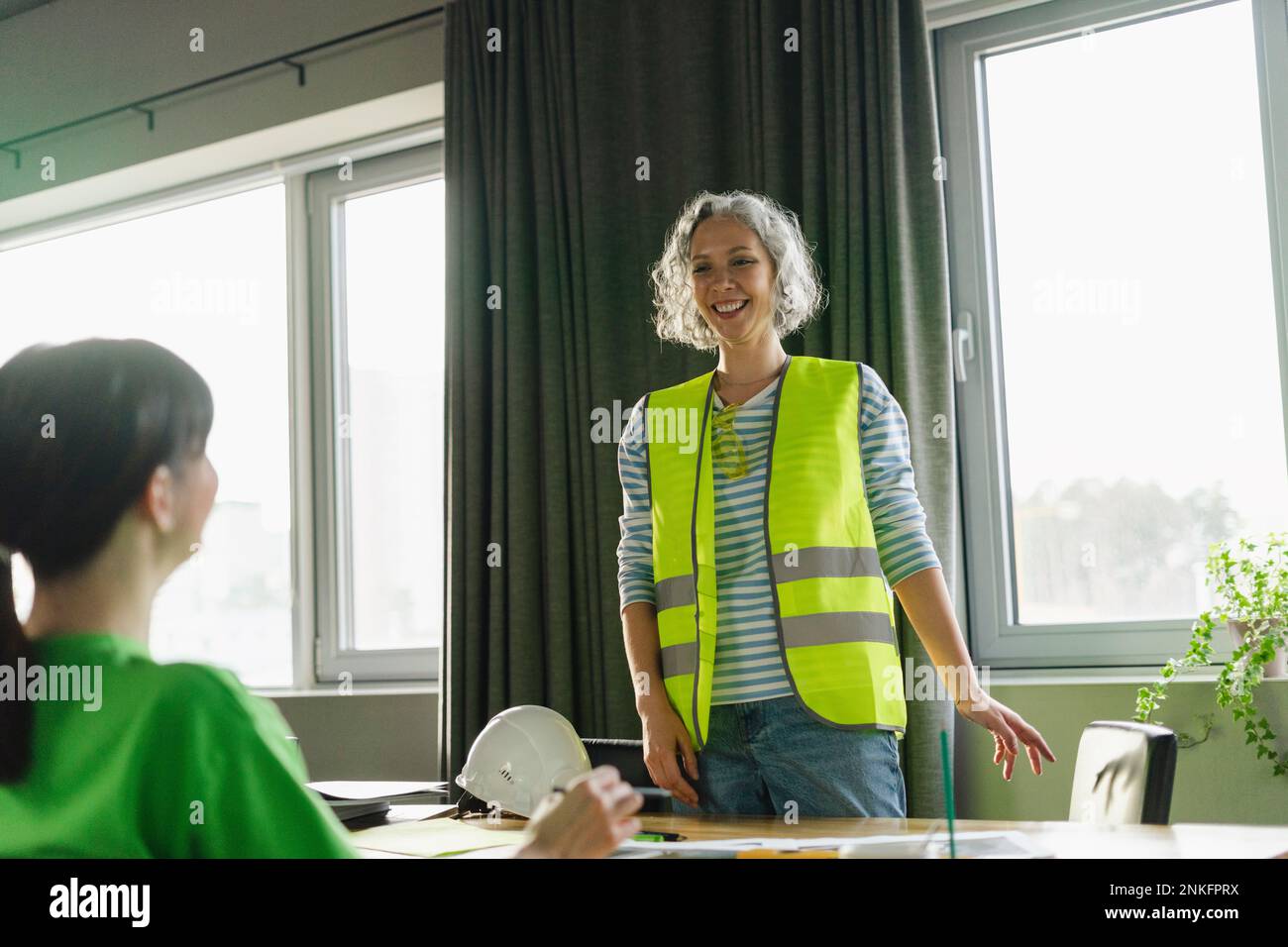 Lächelnde Ingenieurin mit Frau im Konferenzraum Stockfoto