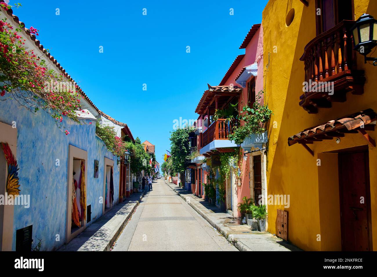 Leere Straße inmitten farbenfroher Häuser unter blauem Himmel Stockfoto