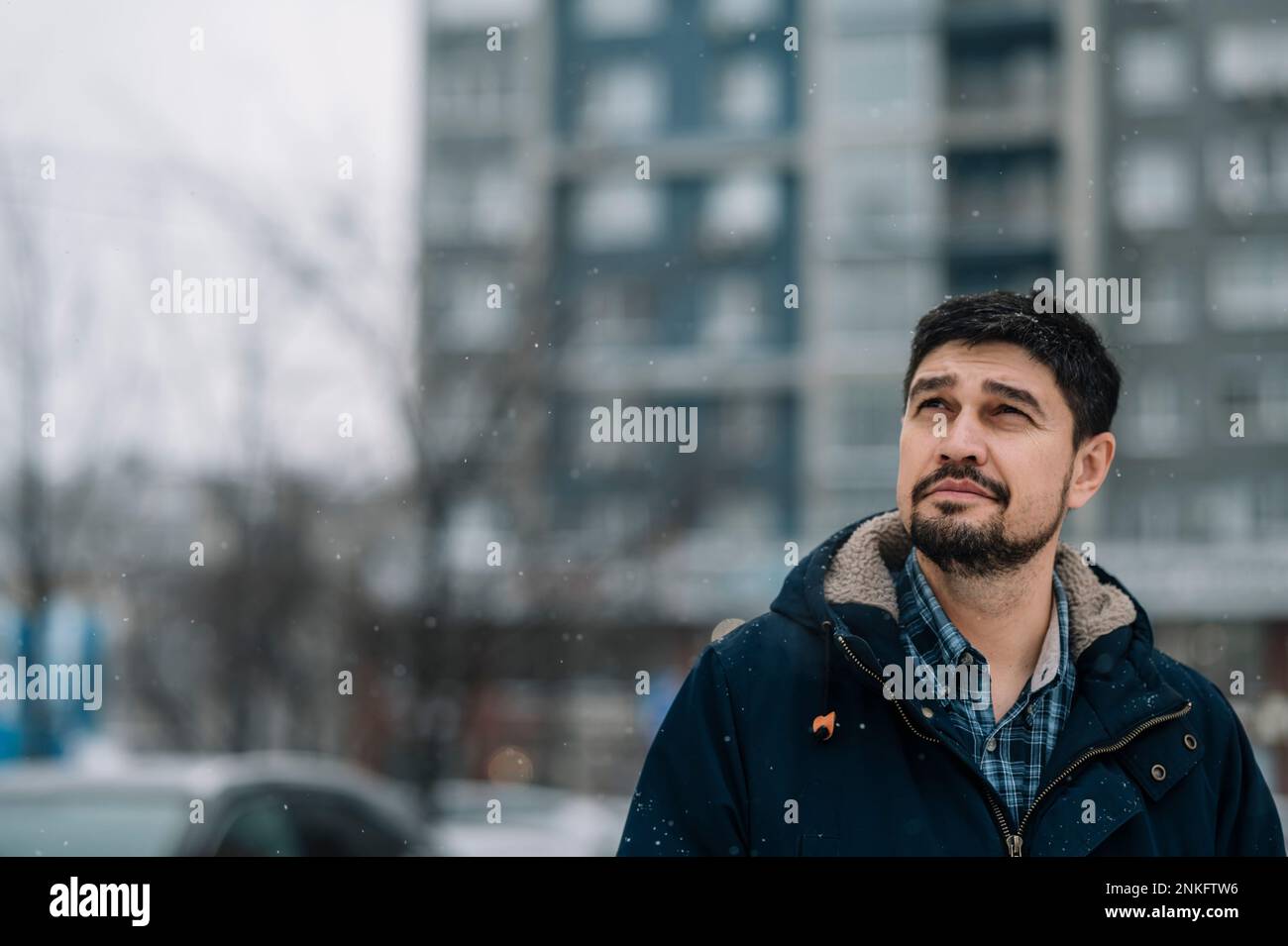 Ein Mann, der bei Schneewetter warme Kleidung trägt Stockfoto