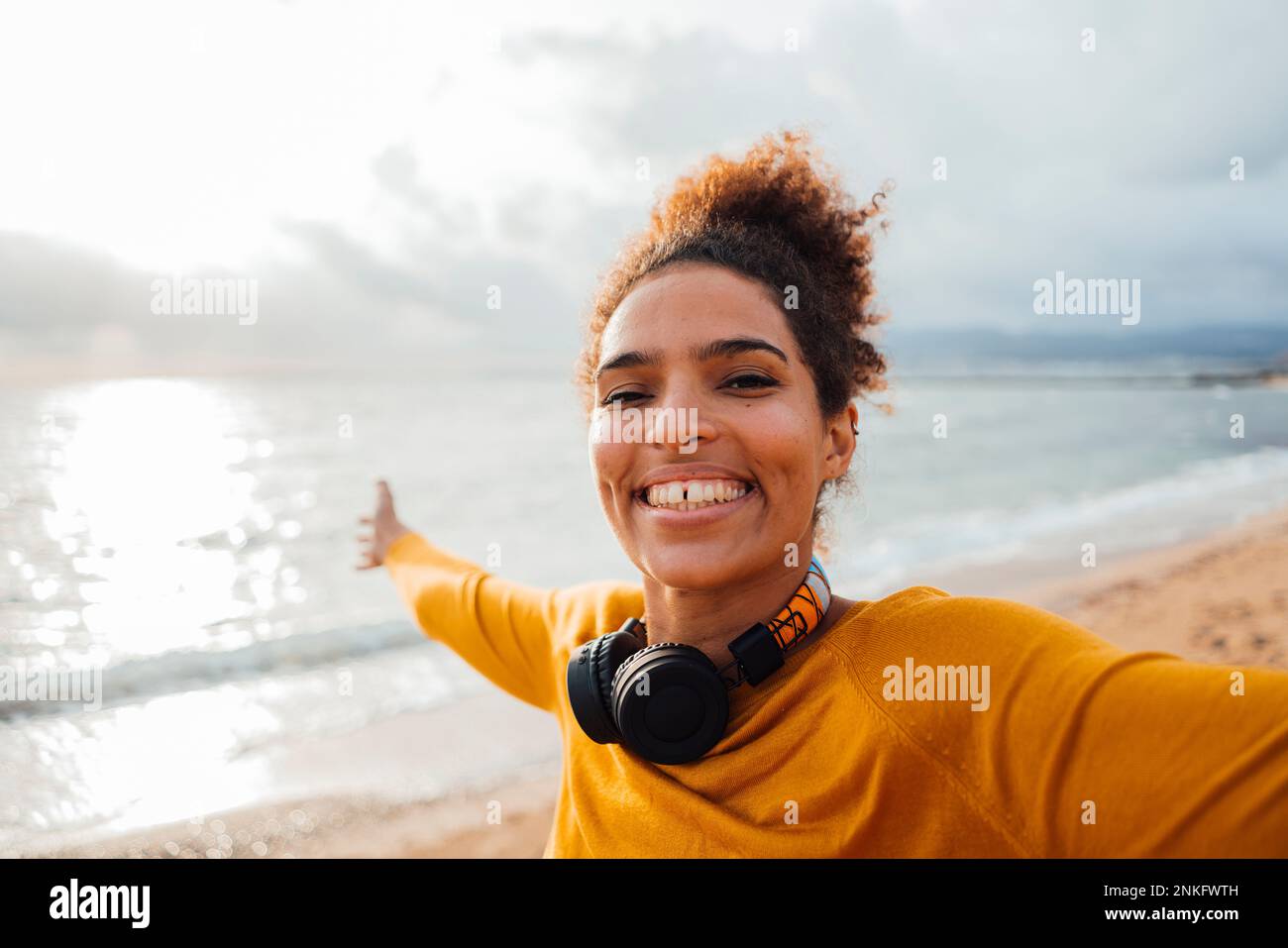 Fröhliche junge Frau, die an sonnigen Tagen Spaß am Strand hat Stockfoto