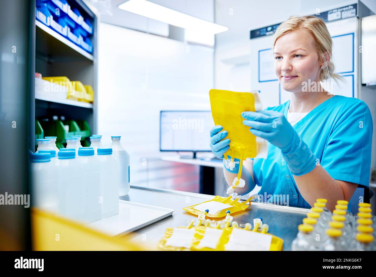 Eine Frau, die eine wissenschaftliche Probe in einem mikrobiologischen Labor hält Stockfoto