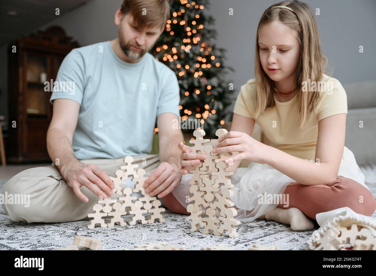 Vater und Tochter spielen zu Hause mit Holzspielzeug Stockfoto