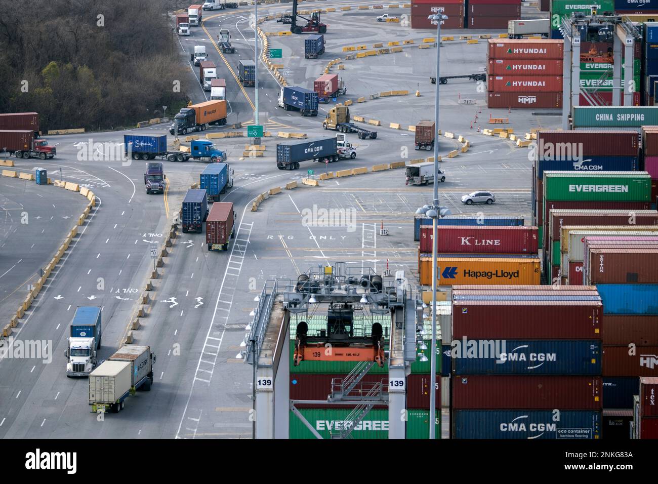 In this photo provided by the Georgia Ports Authority, tractor trailers loaded with shipping containers drive through a traffic circle in the container yard at the Georgia Ports Authority's Garden City Terminal, on Feb. 2, 2022. (AP Photo/Georgia Port Authority, Stephen B. Morton) Stockfoto