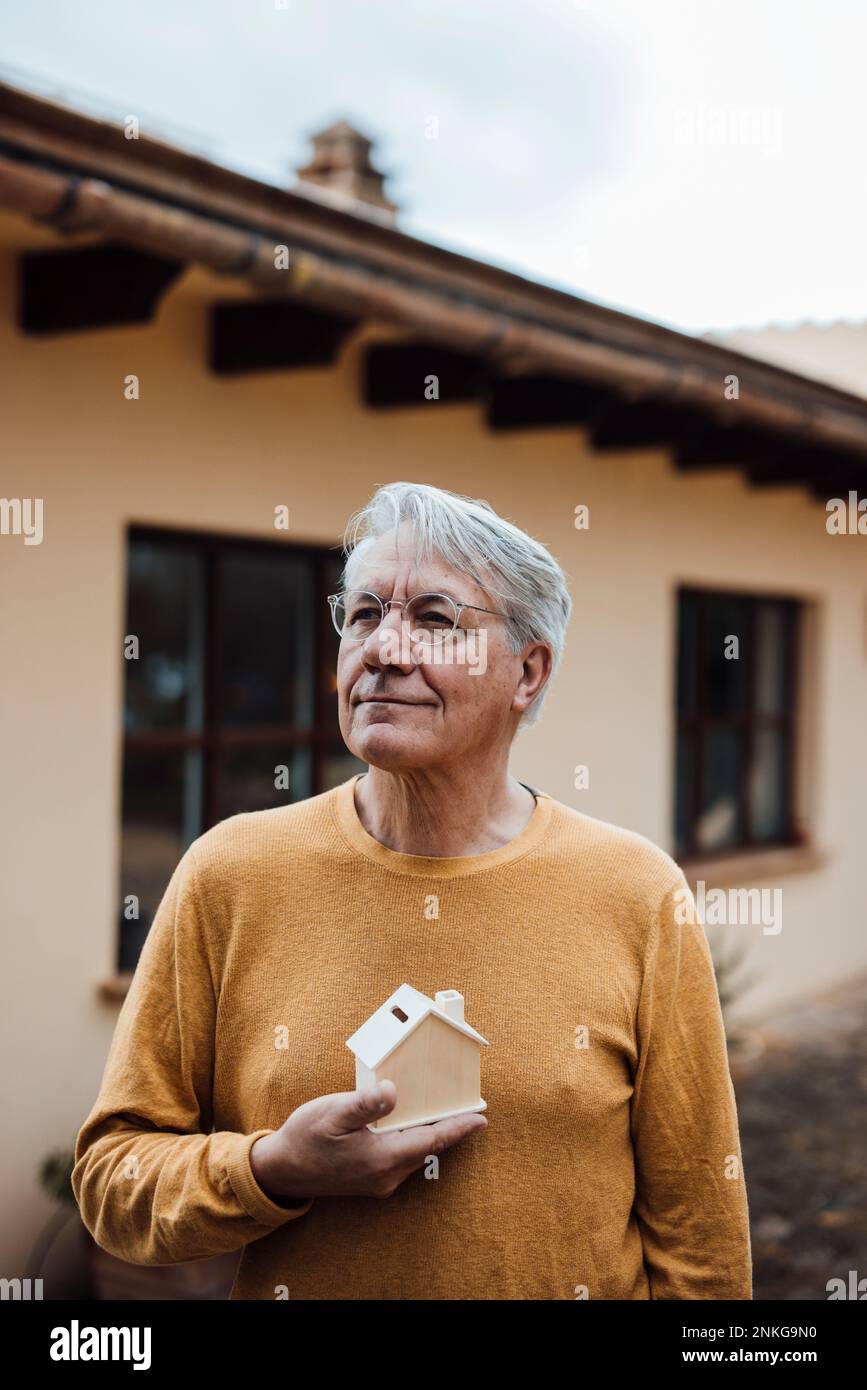 Rücksichtsvoller Seniorenmann mit Vorzeigeheim Stockfoto