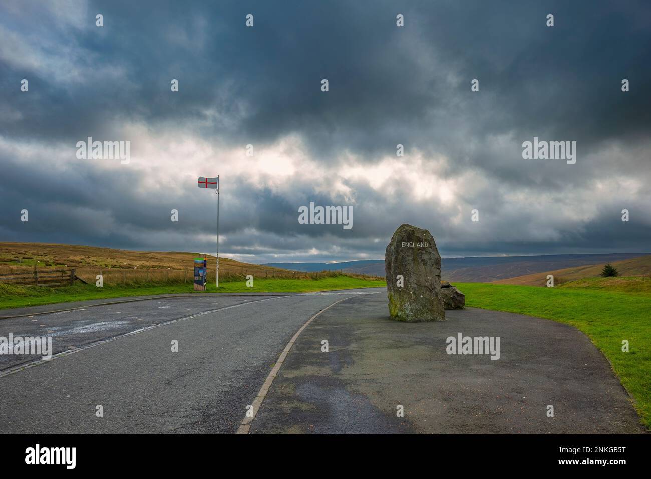 Großer Felsen mit dem Wort "England" und "English Flag", die auf der Straße unter den Sturmwolken winken Stockfoto