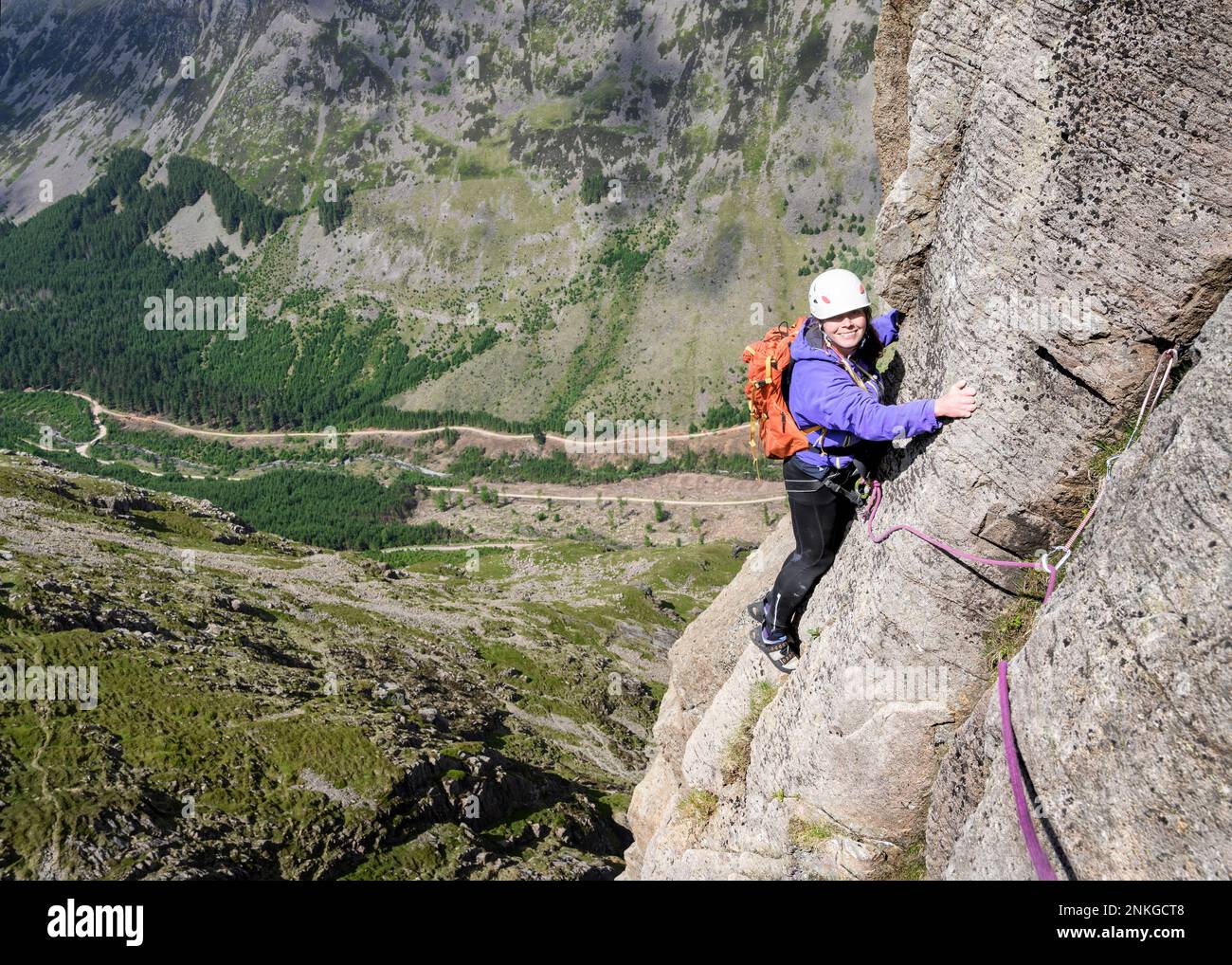 Glückliche Frau, die Bergpfosten erklommen hat, Western Fells, Lake District, England Stockfoto