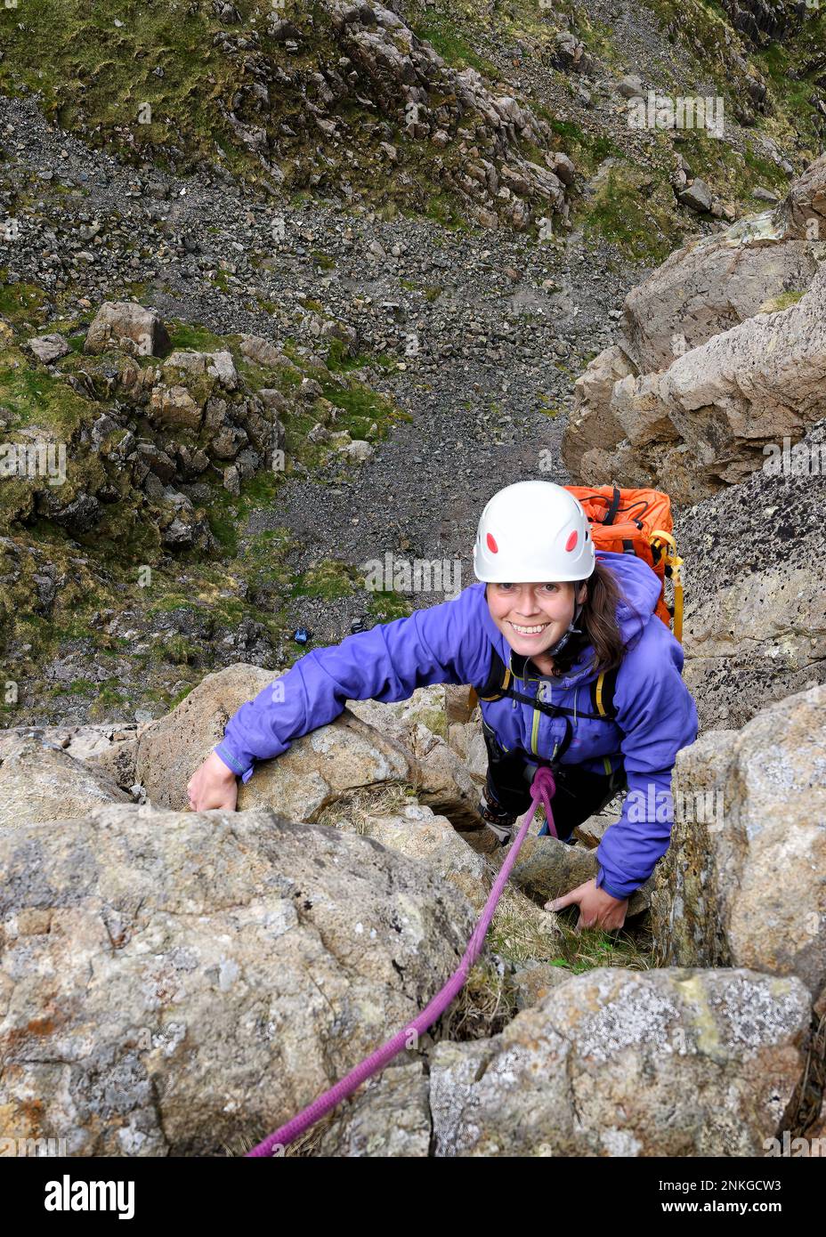 Glückliche Frau mit Helm, kletternder Felsen, Lake District, England Stockfoto