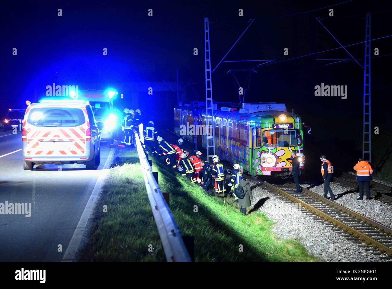 Edingen Neckarhausen, Deutschland. 23. Februar 2023. Rettungskräfte arbeiten am Unfallort. Ein 49-jähriger Fußgänger wurde in Edingen-Neckarhausen (Rhein-Neckar-Bezirk) von einem Auto angefahren und schwer verletzt. Nach ersten Untersuchungen wurde der Fußgänger von hinten von einem Auto auf der rechten Straßenseite getroffen und durch die Kraft des Aufpralls auf ein nahegelegenes Bahnbett geworfen, wo ein eintreffender Pendlerzug gerade rechtzeitig bremsen konnte, sagte die Polizei Freitagabend. Der 49-Jährige wurde in ein Krankenhaus gebracht. Es gab keine Lebensgefahr. Kredit: R.Priebe/PR-Video/dpa/Alamy Live News Stockfoto