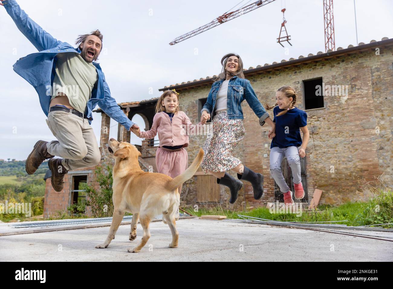 Sorglose Familie, die vor dem Haus von einem Hund gesprungen ist Stockfoto