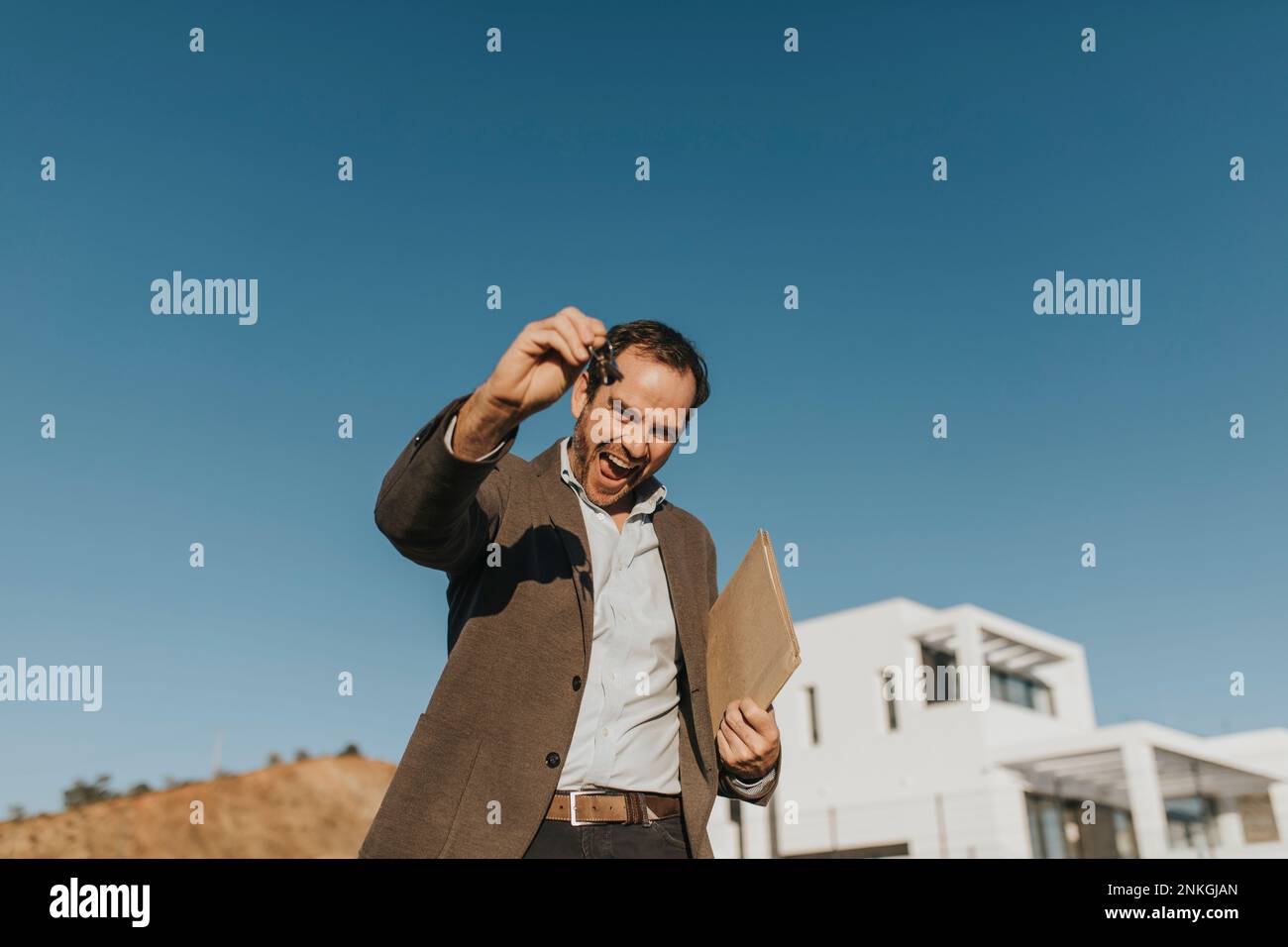 Glücklicher Mann mit Hausschlüssel Stockfoto