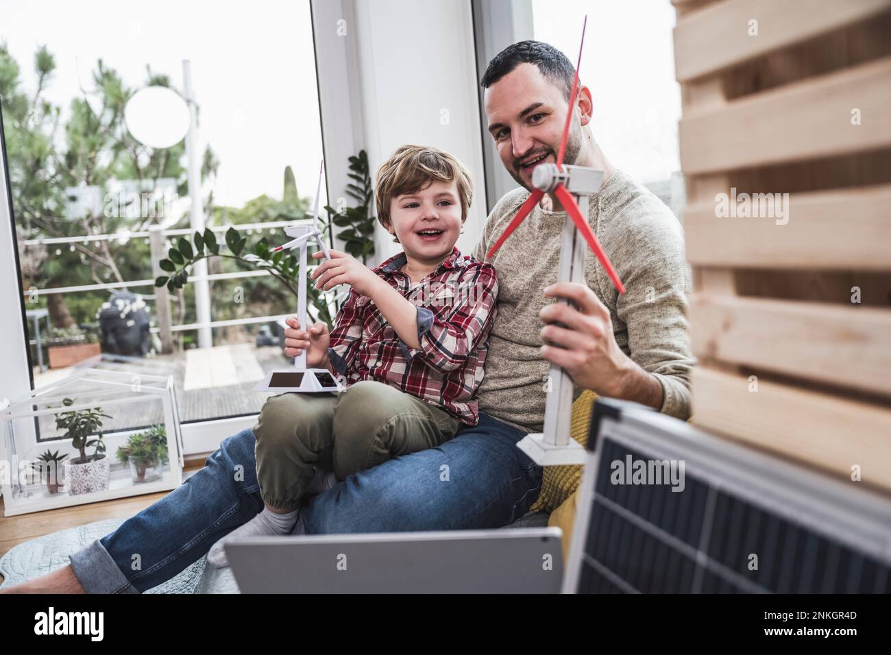 Vater und Sohn, die zu Hause mit Windkraftmodellen spielen Stockfoto